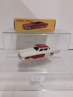 a red and white toy car on display in a glass case