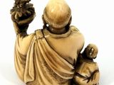 statue of a man holding a cat and a dog on a white surface