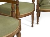 pair of green upholstered chairs with wood arms and arms