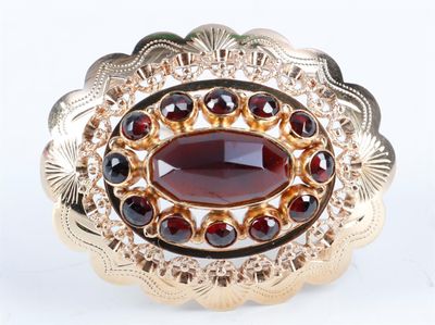 une image représentant une bague en or sertie d'une pierre de grenat entourée de grenats