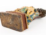 a small statue of a person laying on a book