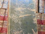 many old books stacked on top of each other on a table