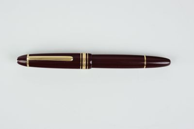 un gros plan d'un stylo posé sur une surface blanche