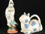 deux figurines en céramique représentant une femme et un chat sur fond noir