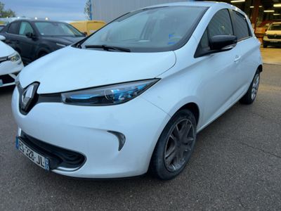 une voiture blanche garée sur un parking, avec d'autres voitures en arrière-plan