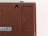 the bottom of a brown cell phone with a number on it