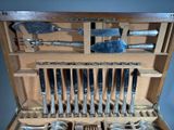 a wooden box with a bunch of silverware inside of it