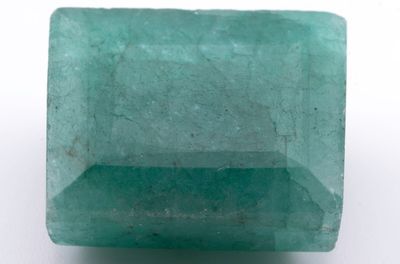 gros plan d'une pierre d'émeraude verte sur une surface blanche