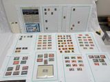 de nombreux timbres posés sur une table, à côté d'une feuille de papier blanche