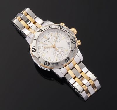 a close up of a watch on a black surface with a black background