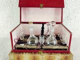 a red box with a set of wine glasses and decanters in it