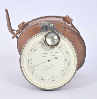 a small clock with a leather case on it