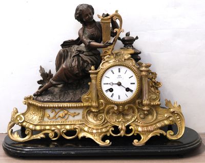 a statue of a woman sitting on top of a clock