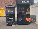 two vending machines in a parking lot next to a building