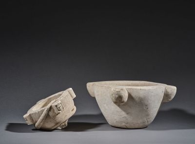 a white marble bowl and a bowl with a lid on a table