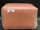 an orange blanket wrapped in plastic sitting on top of a table