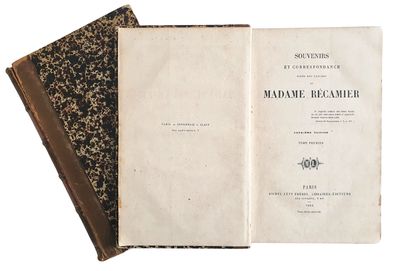 un livre ouvert, à la couverture noire, posé sur une table