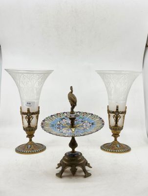 trois vases en verre posés sur une table, avec un oiseau perché dessus