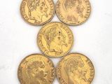 five gold sovereigns of different sizes and shapes