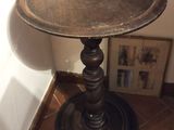 une petite table avec un plateau en métal posée sur un sol carrelé