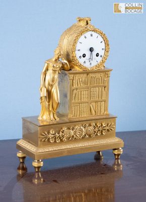 une horloge en or posée sur une table en bois