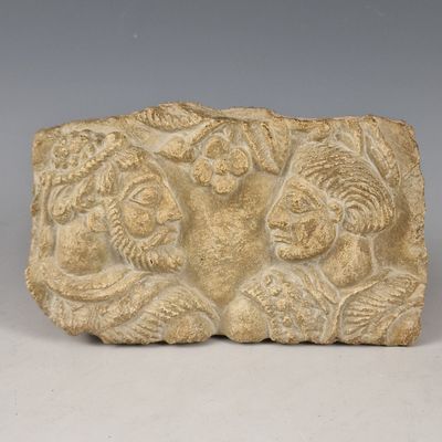 une image représentant un bloc de pierre orné d'un relief représentant un homme et une femme