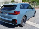 a blue bmw suv parked on the side of the road