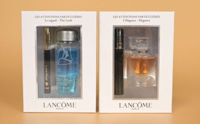 two bottles of perfume in a white box on a brown surface