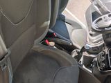 l'intérieur d'une voiture avec les sièges avant rabattus et un volant au centre