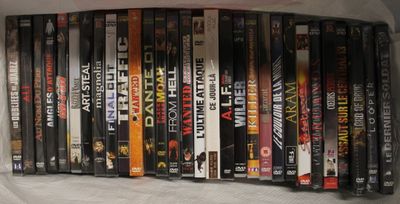 beaucoup de DVD empilés les uns sur les autres sur une étagère