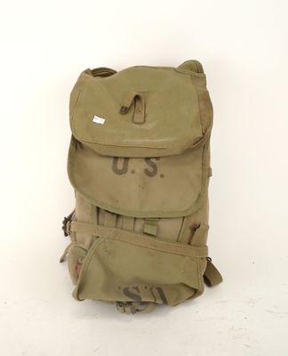 an old us military backpack sitting on top of a white floor