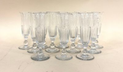 six verres à vin transparents sont alignés sur une surface blanche