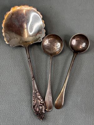 three spoons and two spoons sitting on a table