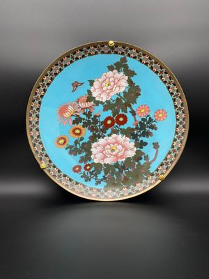 une assiette bleue et dorée ornée de fleurs et d'oiseaux