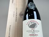 a bottle of wine sitting next to a wooden box