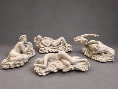 un ensemble de quatre statues représentant une femme et un homme sur un rocher