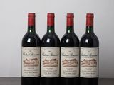 four bottles of wine are lined up on a wooden table