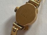 a gold watch that is on a white surface