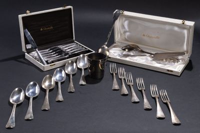 des couverts dans un coffret en argent posé sur une table noire