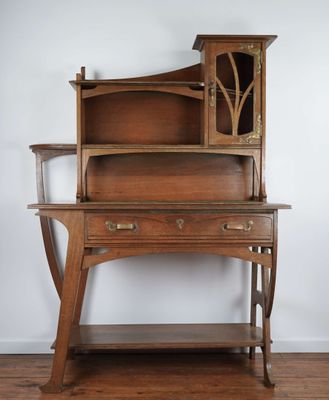 an old wooden desk with a glass door on top of it