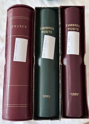trois livres sont posés dans une boîte sur un lit, à côté d'une tasse de café
