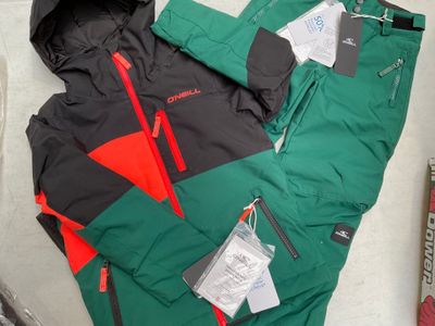 une veste et un pantalon verts et rouges posés par terre