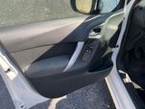 the interior of a car with the door open and the driver ' s seat down