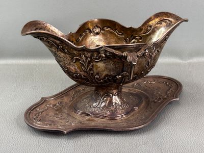a silver plate with a bowl on it on a table