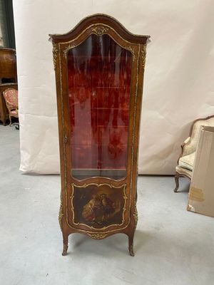 an antique display cabinet with a red glass door and gold trimming