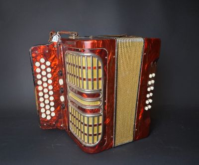 an image of a red accordion sitting on top of a black table