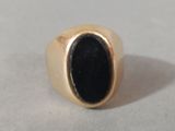 an image of a gold ring with a black stone in it