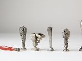 five different types of silver objects on a white surface