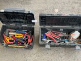 two black cases with tools in them sitting on the ground