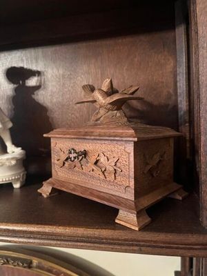 une petite boîte en bois posée sur une étagère dans un coin de la pièce